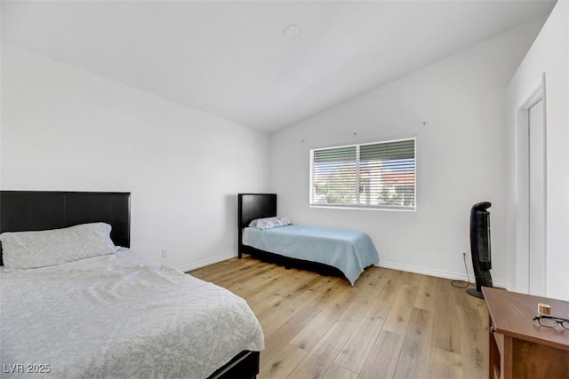 bedroom featuring lofted ceiling and light hardwood / wood-style flooring