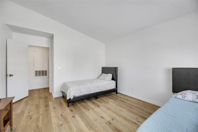 bedroom with light hardwood / wood-style flooring and lofted ceiling