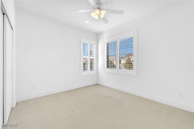 carpeted spare room featuring ceiling fan