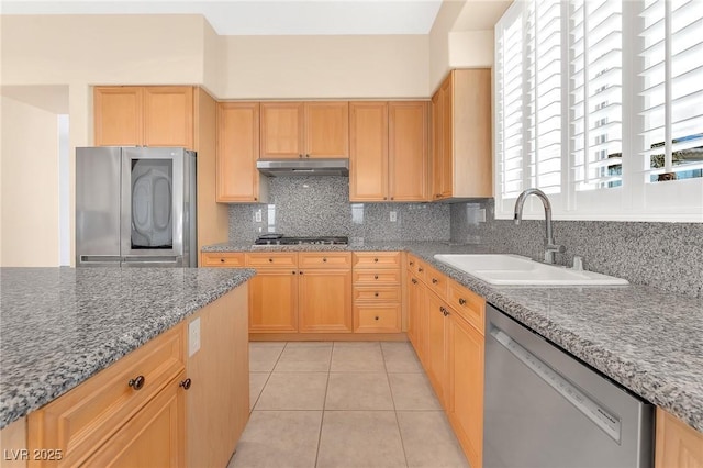 kitchen featuring stainless steel appliances, sink, light tile patterned floors, tasteful backsplash, and light brown cabinetry