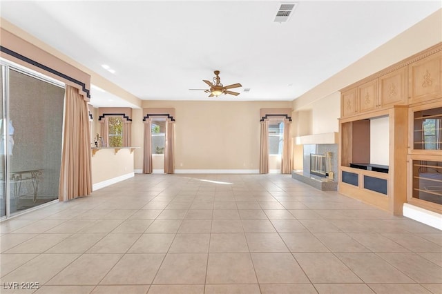 unfurnished living room featuring ceiling fan, a multi sided fireplace, and light tile patterned floors