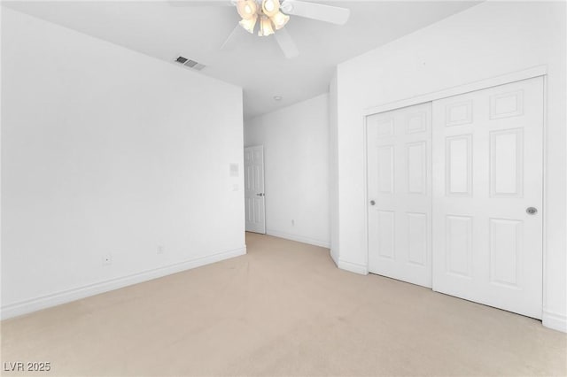 unfurnished bedroom with a closet, light carpet, and ceiling fan