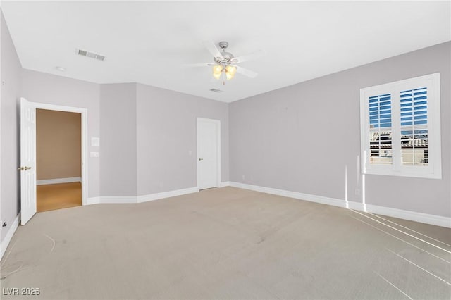 empty room with ceiling fan and light colored carpet