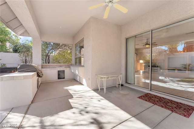 view of patio with area for grilling and ceiling fan