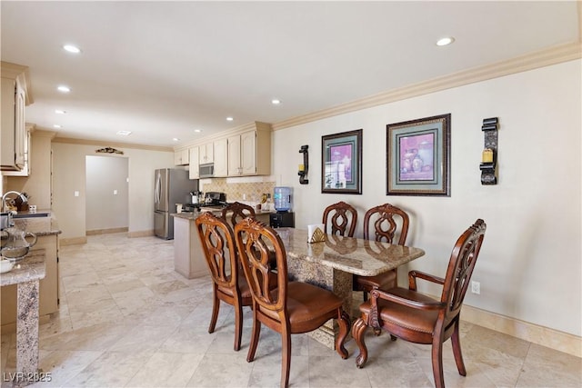 dining room featuring ornamental molding and sink