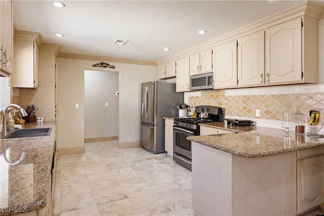 kitchen with kitchen peninsula, appliances with stainless steel finishes, light stone counters, crown molding, and sink