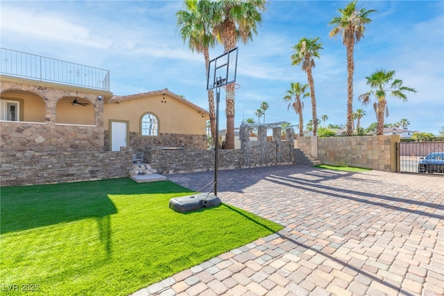 view of sport court with a lawn