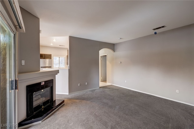 unfurnished living room with light carpet and a fireplace