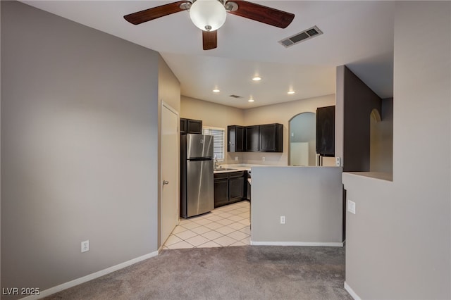 kitchen with ceiling fan, light carpet, and stainless steel refrigerator