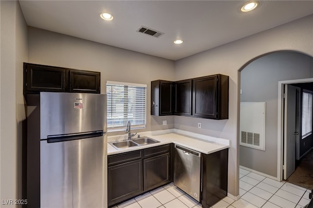 kitchen with light tile patterned floors, stainless steel appliances, dark brown cabinets, and sink