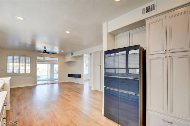 unfurnished living room featuring ceiling fan and light hardwood / wood-style floors