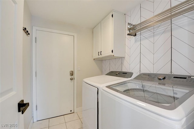 laundry room featuring cabinets, washer and clothes dryer, and light tile patterned flooring