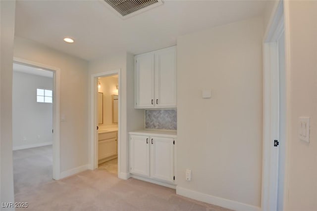 corridor featuring light colored carpet