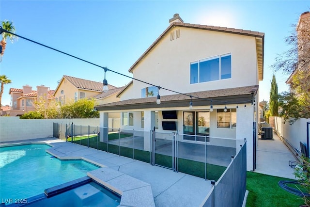 rear view of house with a patio area, a fenced in pool, and central AC