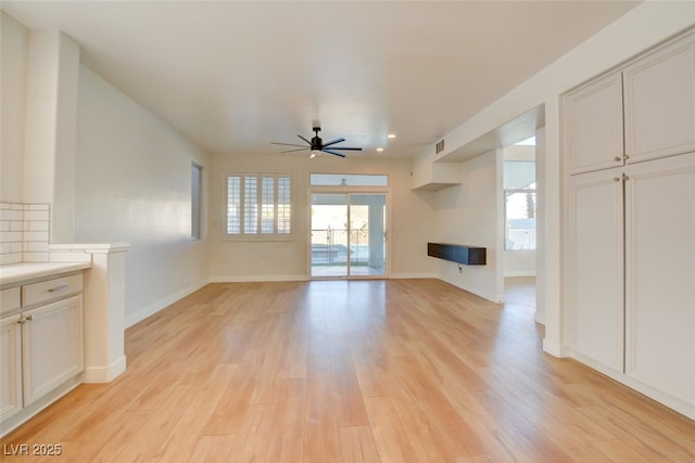 unfurnished living room with ceiling fan and light hardwood / wood-style floors