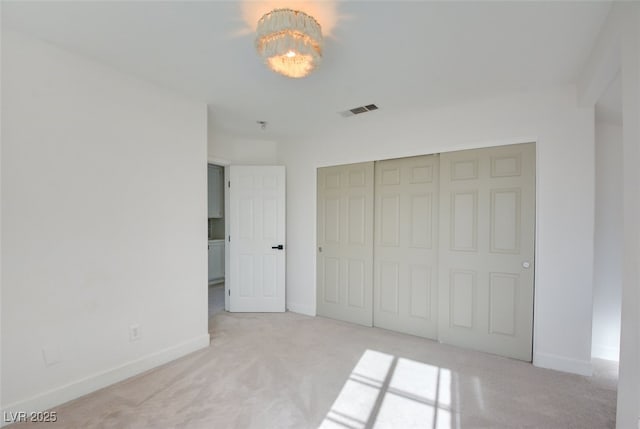 unfurnished bedroom with light carpet and a closet