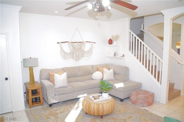 living room with ceiling fan with notable chandelier, light tile patterned floors, and crown molding