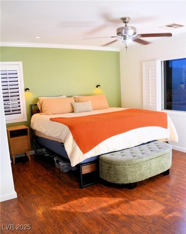 bedroom featuring ceiling fan, crown molding, and dark wood-type flooring