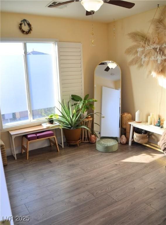 sitting room with ceiling fan and wood-type flooring