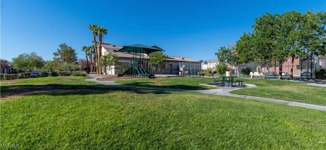 view of property's community featuring a lawn and a playground