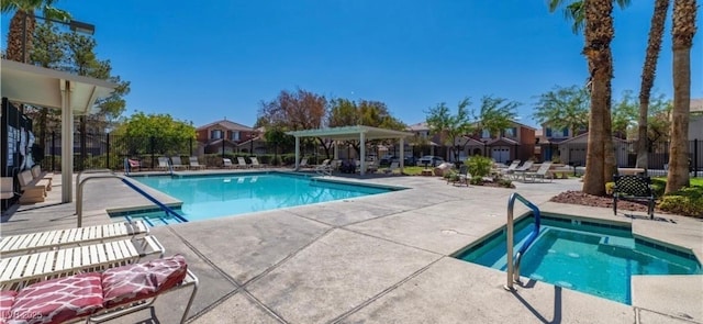 view of swimming pool featuring a hot tub and a patio area