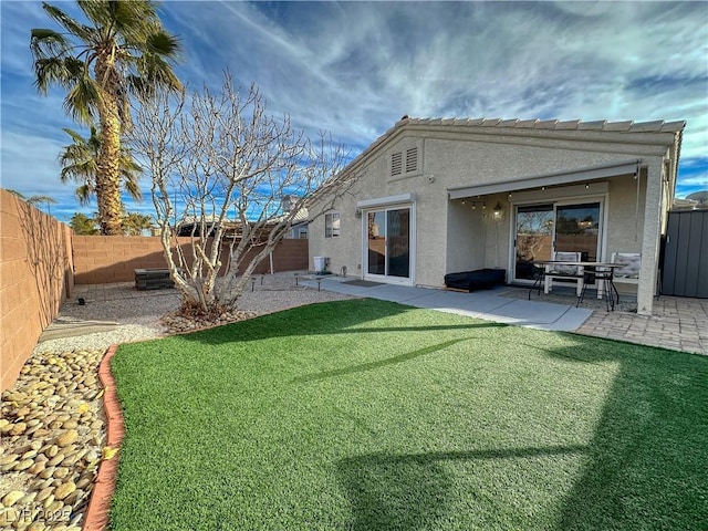 rear view of property with a lawn and a patio area