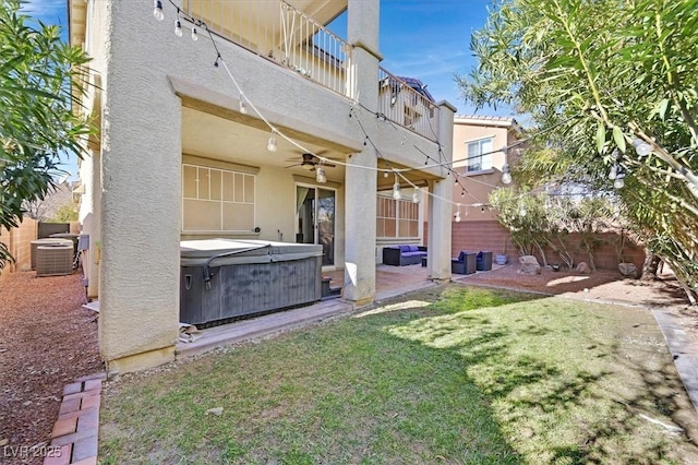 view of yard with ceiling fan, a hot tub, central air condition unit, a balcony, and a patio area