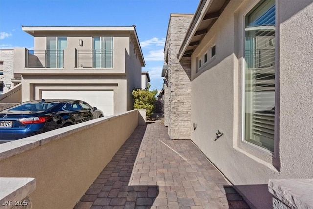 view of side of property featuring a garage and a balcony