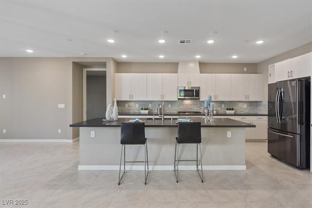 kitchen featuring sink, a breakfast bar area, stainless steel appliances, and a center island with sink