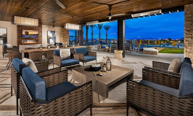 patio terrace at dusk with ceiling fan and an outdoor living space