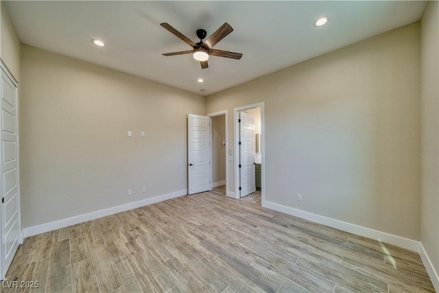 unfurnished bedroom featuring connected bathroom, light hardwood / wood-style flooring, and ceiling fan