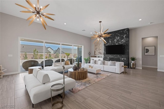 living room featuring a chandelier, a wealth of natural light, and a fireplace