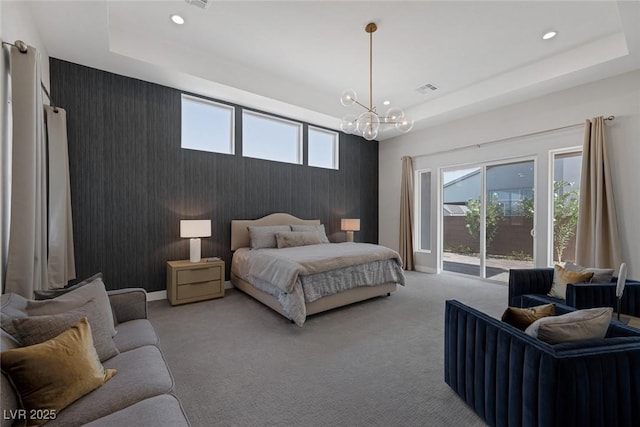 carpeted bedroom with a raised ceiling and a notable chandelier