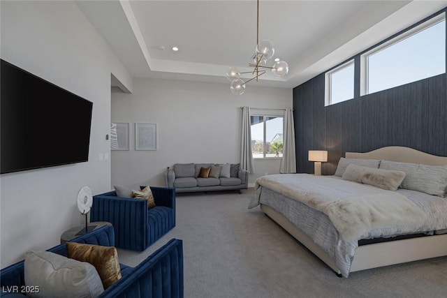 bedroom with a tray ceiling, carpet floors, and a chandelier