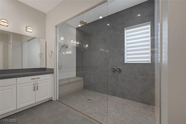 bathroom featuring tile patterned floors, vanity, and a tile shower