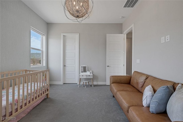 carpeted bedroom featuring a crib and an inviting chandelier