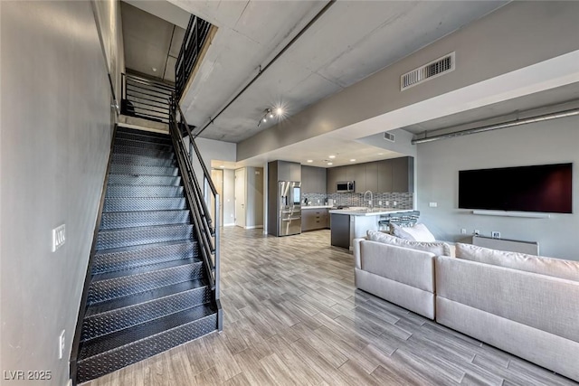 stairway featuring hardwood / wood-style flooring and sink