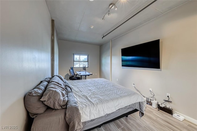 bedroom with light wood-type flooring and track lighting