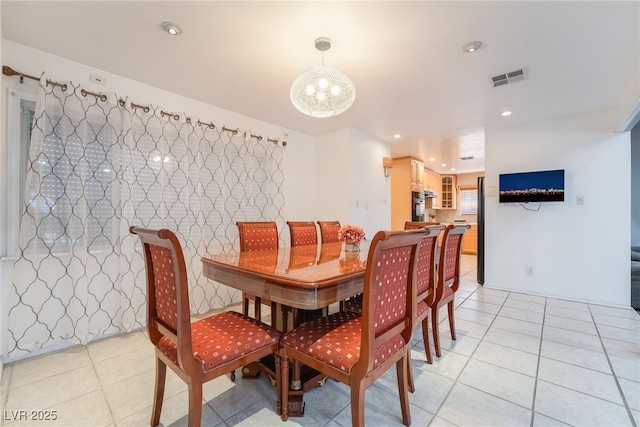 dining space featuring light tile patterned flooring and a chandelier