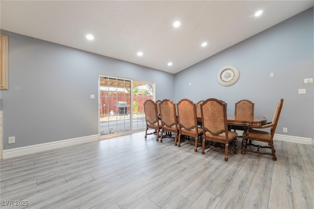 dining room featuring light hardwood / wood-style floors and lofted ceiling