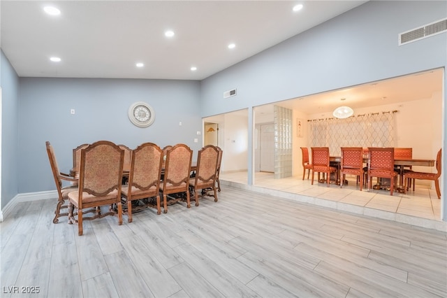 dining space featuring a high ceiling and light wood-type flooring