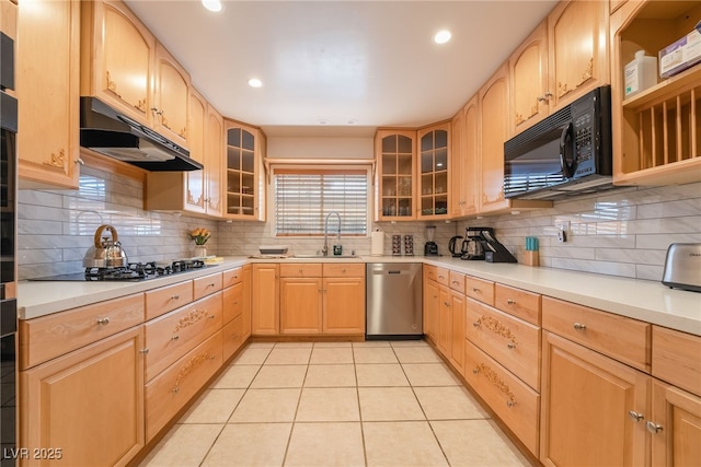 kitchen with light brown cabinetry, tasteful backsplash, stainless steel dishwasher, and sink