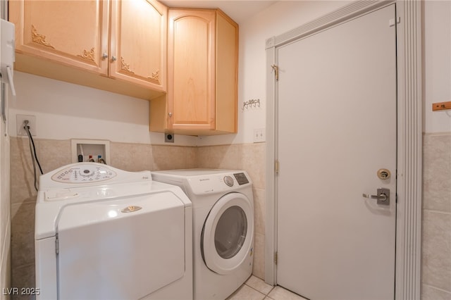 laundry area with cabinets, separate washer and dryer, and light tile patterned floors