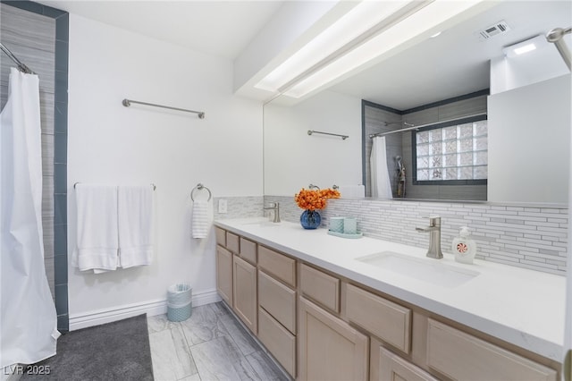 bathroom with vanity and tasteful backsplash