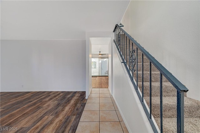 stairway featuring tile patterned floors and ceiling fan