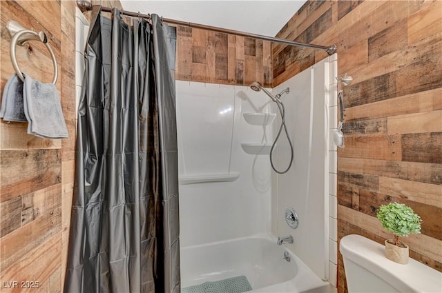 bathroom featuring toilet, wooden walls, and shower / tub combo