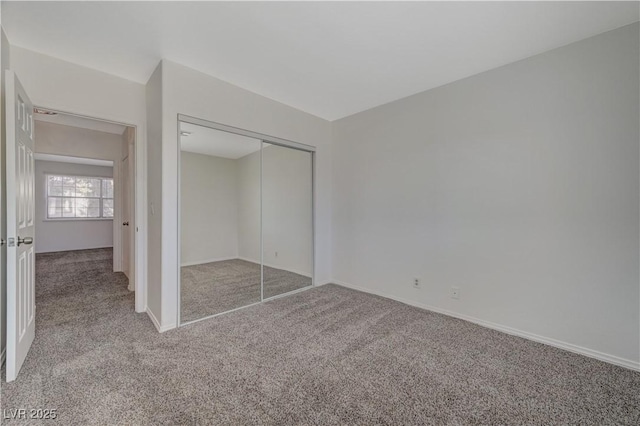 unfurnished bedroom with light carpet and a closet