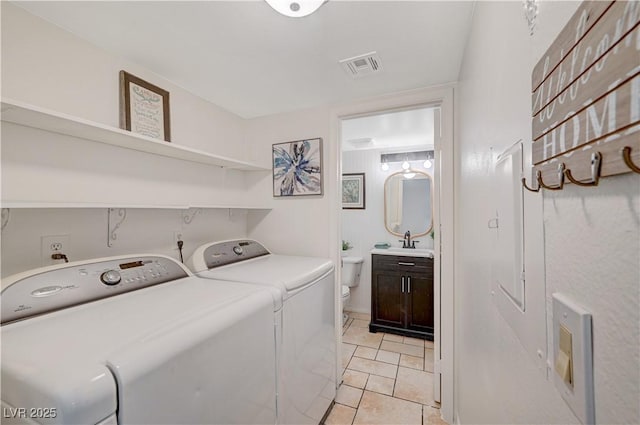 washroom with washer and clothes dryer, light tile patterned floors, and sink