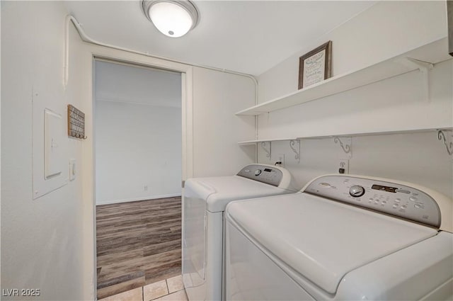 washroom featuring washing machine and clothes dryer and light hardwood / wood-style floors