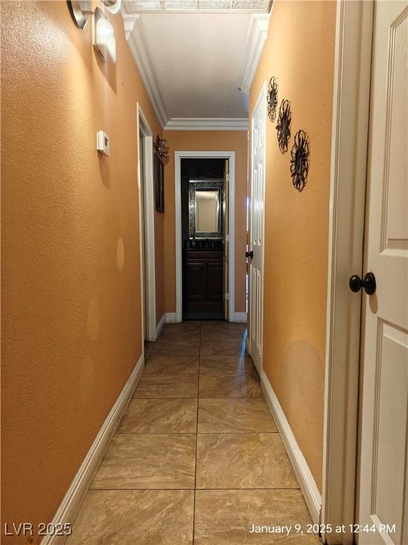 corridor with ornamental molding and light tile patterned floors